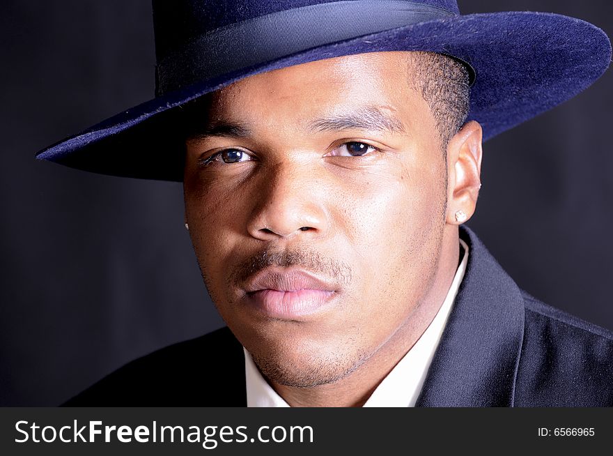 Young African American man in a hat and suit