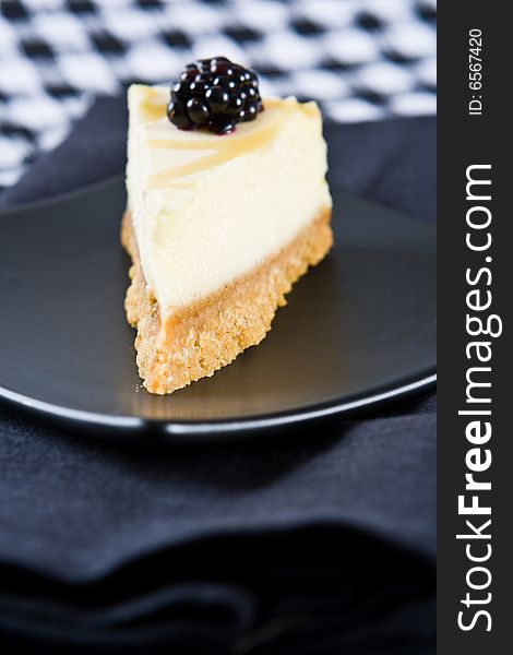 Delicious homemade lemon cheesecake on a black plate