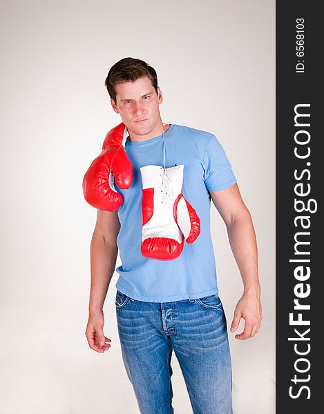 Rugged sexy man stands with boxing gloves over shoulders. Rugged sexy man stands with boxing gloves over shoulders