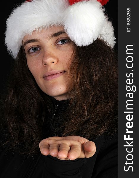 Beautiful russian woman in closeup with asnta hat on for the holidays, holding hand out in front of her