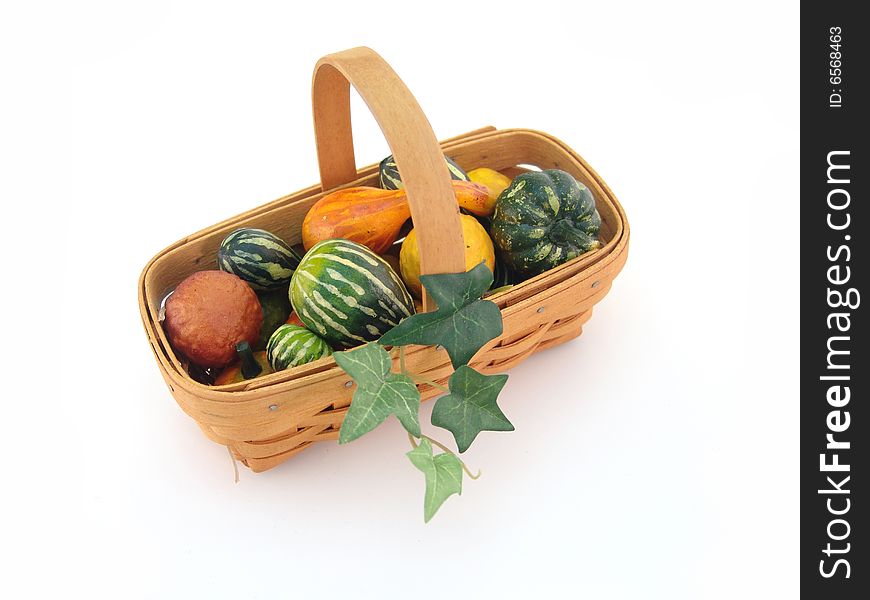 Small basket with gourds and leaves isolated over white. Small basket with gourds and leaves isolated over white