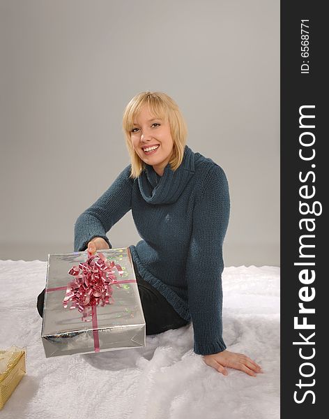 Cute blond giving present wrapped in decorative Christmas paper. Cute blond giving present wrapped in decorative Christmas paper