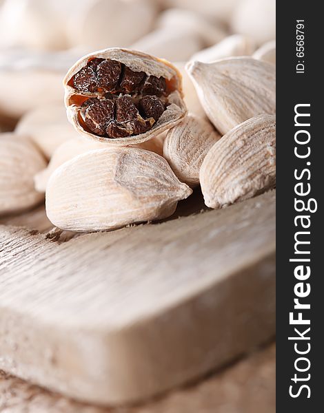 White cardamom pods on old wood, one opened, super macro, shallow DOF. White cardamom pods on old wood, one opened, super macro, shallow DOF