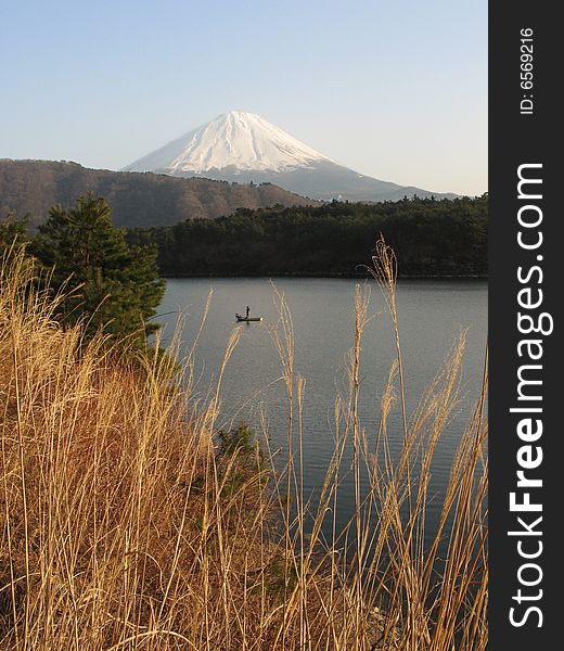 Fisherman in a lake by Mount Fuji. Fisherman in a lake by Mount Fuji