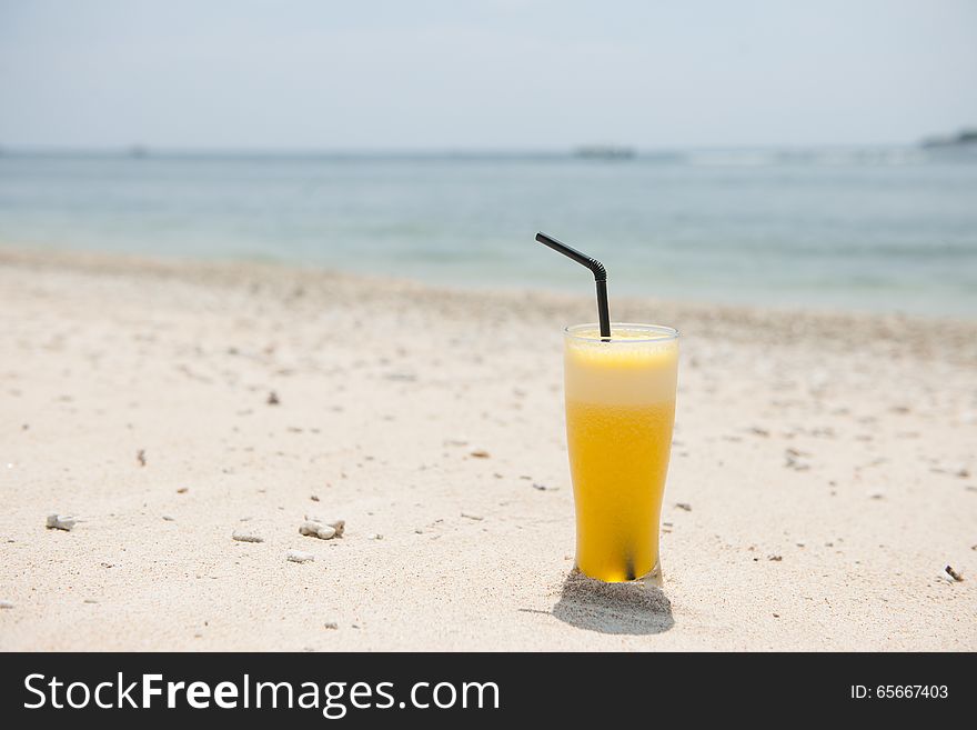 Stock picture of fresh pineapple juice on the beach