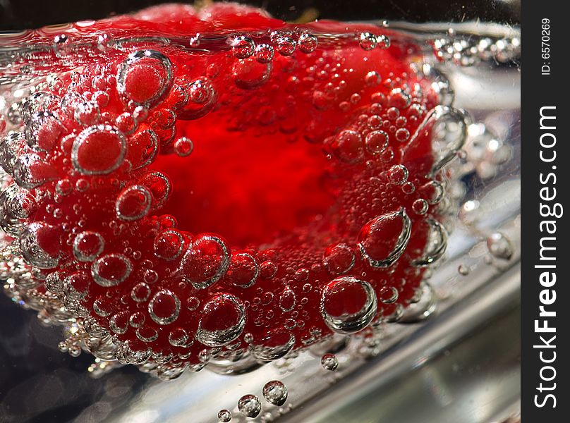 A raspberry floating in a glass of tonic water. A raspberry floating in a glass of tonic water.