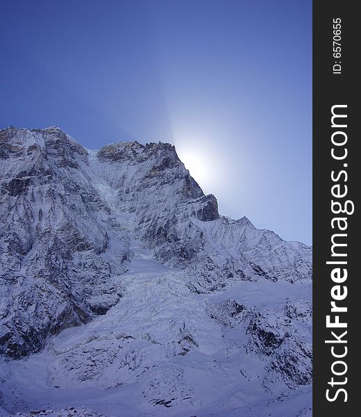 Rays of sunlight streaming behind the peak of the mountain. Along the sikkim, mount kanchenjunga trek. Rays of sunlight streaming behind the peak of the mountain. Along the sikkim, mount kanchenjunga trek