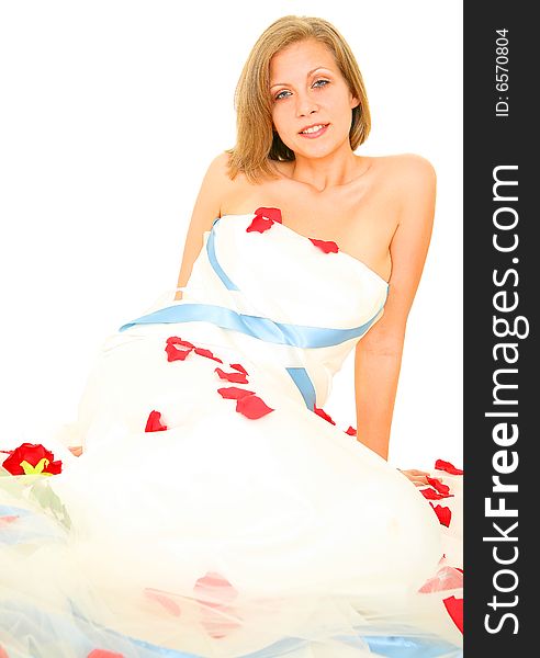 Happy beautiful caucasian bride in her gown sitting with rose petal around her. Happy beautiful caucasian bride in her gown sitting with rose petal around her