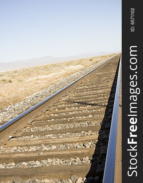 Railroad track in the Nevada desert with vanishing point and some blue sky for copy space. Railroad track in the Nevada desert with vanishing point and some blue sky for copy space.