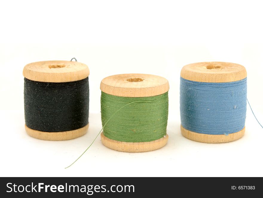 Isolated blue, green & black spools on white background. Isolated blue, green & black spools on white background