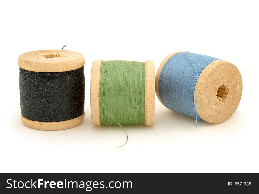 Isolated blue, green & black spools on white background. Isolated blue, green & black spools on white background