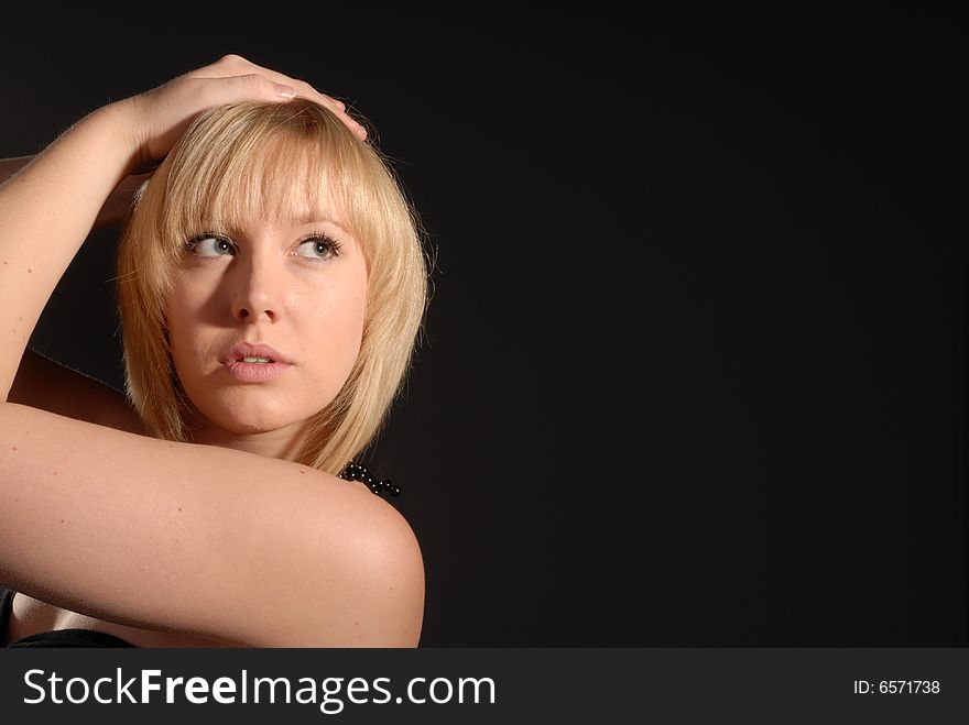 Sexy blond glamour girl posing against dark background