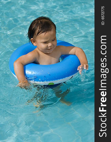 Baby with swimming tires in a pool for the refreshment