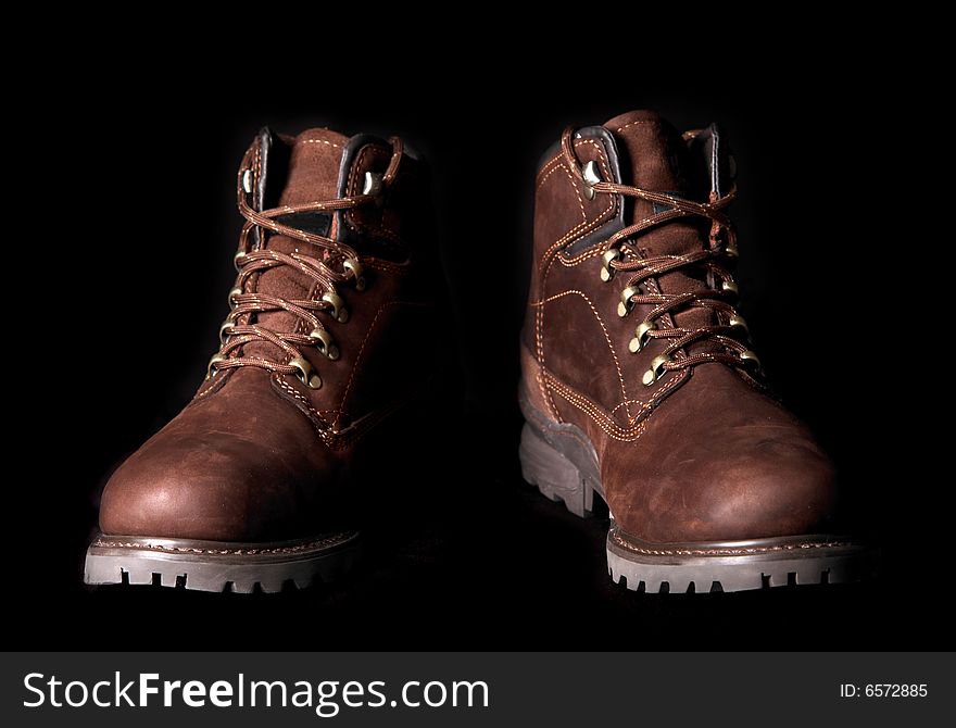 Pair of brown boots  on black background.