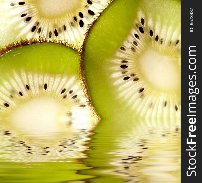 Kiwi slices reflected in water. Kiwi slices reflected in water