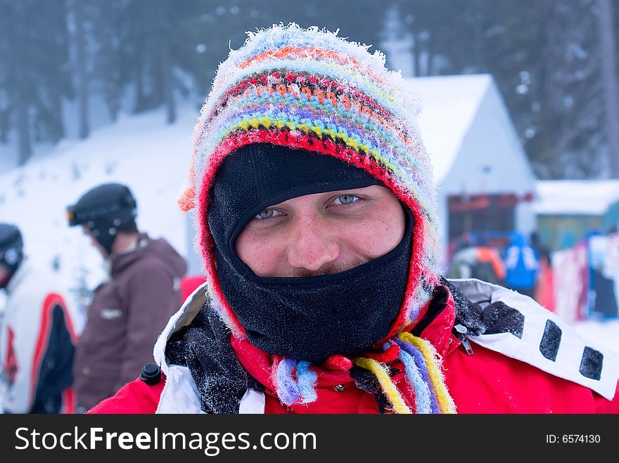 Masked skier man in funny hat Laughing on mountain resort in Europe