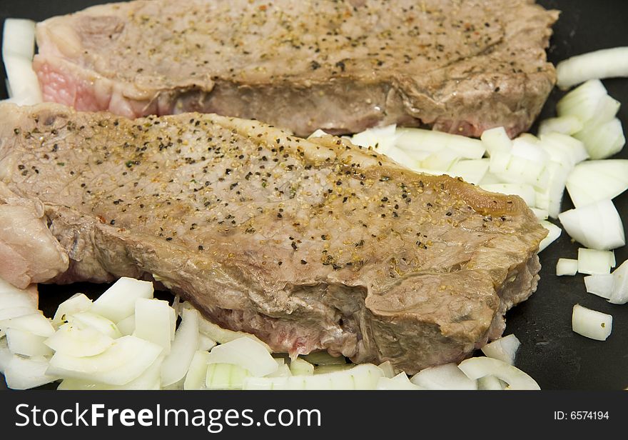 Strip Steaks in Pan with Onions