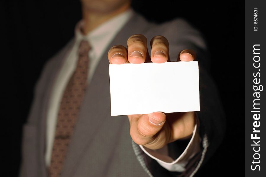 Business man holding visiting card on black