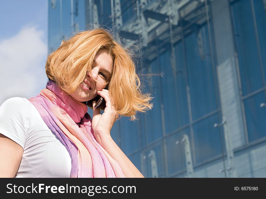 One woman calling on phone in front of modern building. One woman calling on phone in front of modern building
