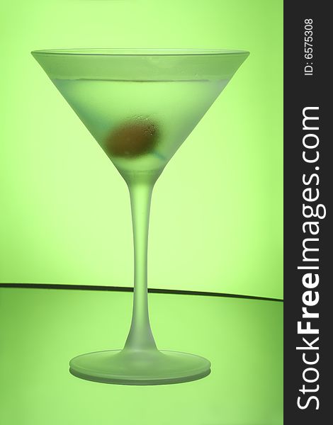 Green Apple Martini in frosted glass, against green gel background.