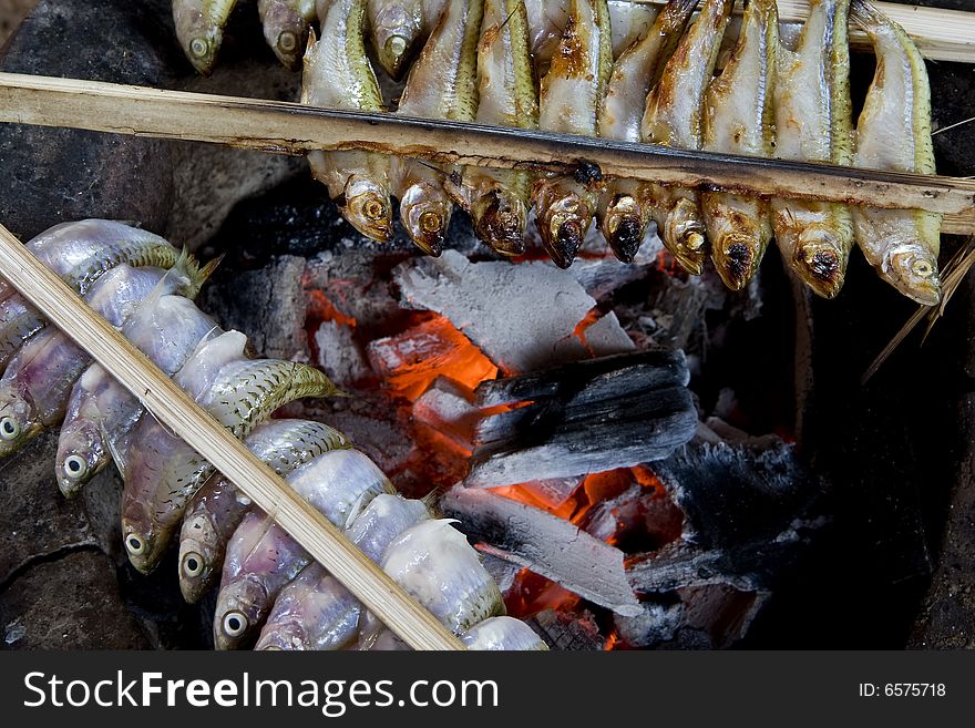 Fish grill with coal, with sticks fixed