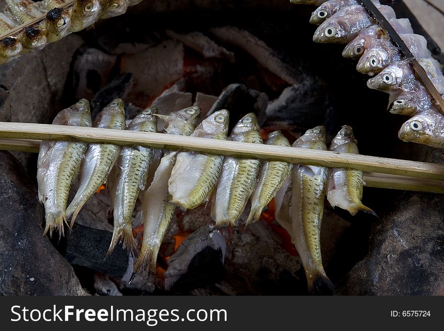 Fish grill with coal, with sticks fixed