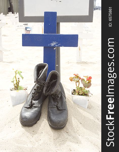 Soldier boots in front of a blue cross