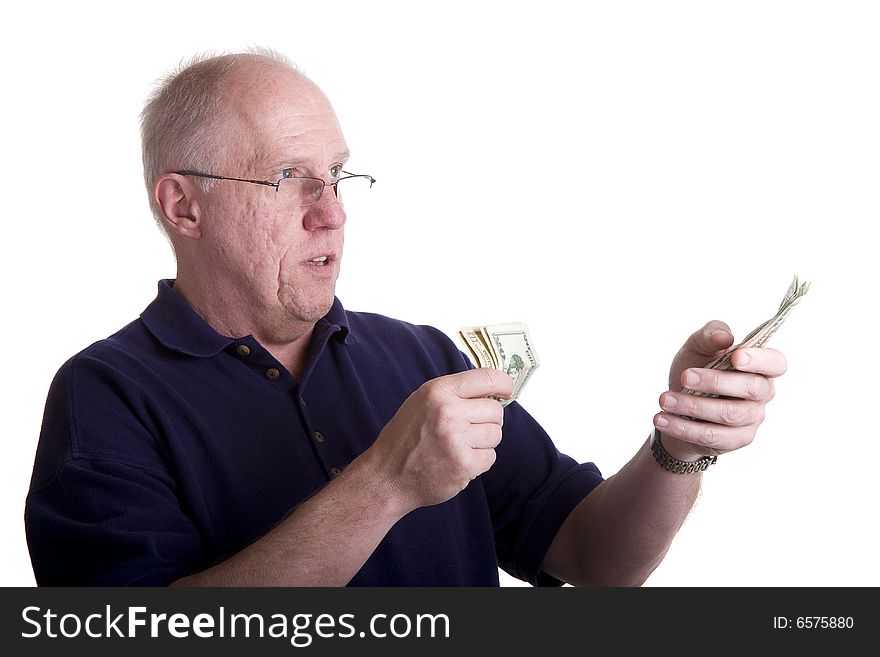 An older bald guy in a blue shirt counting out money. An older bald guy in a blue shirt counting out money