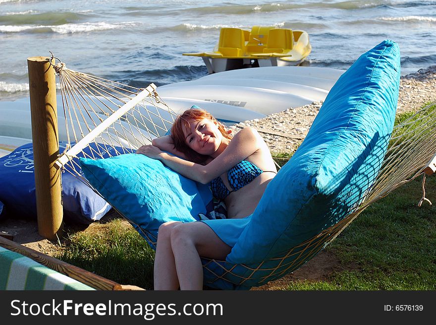 Girl sitting on hammock near the sea