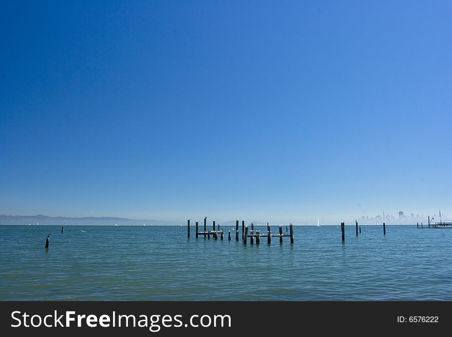 Sea poles with the city of San Francisco in the back with fog surrounding it