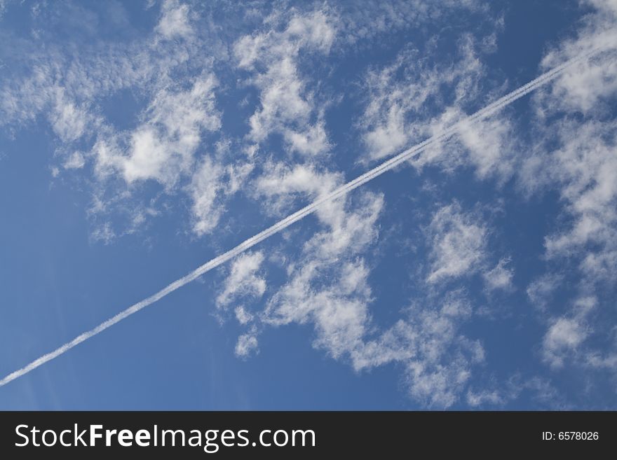 Airplane traces over a blue cloudy sky. Airplane traces over a blue cloudy sky