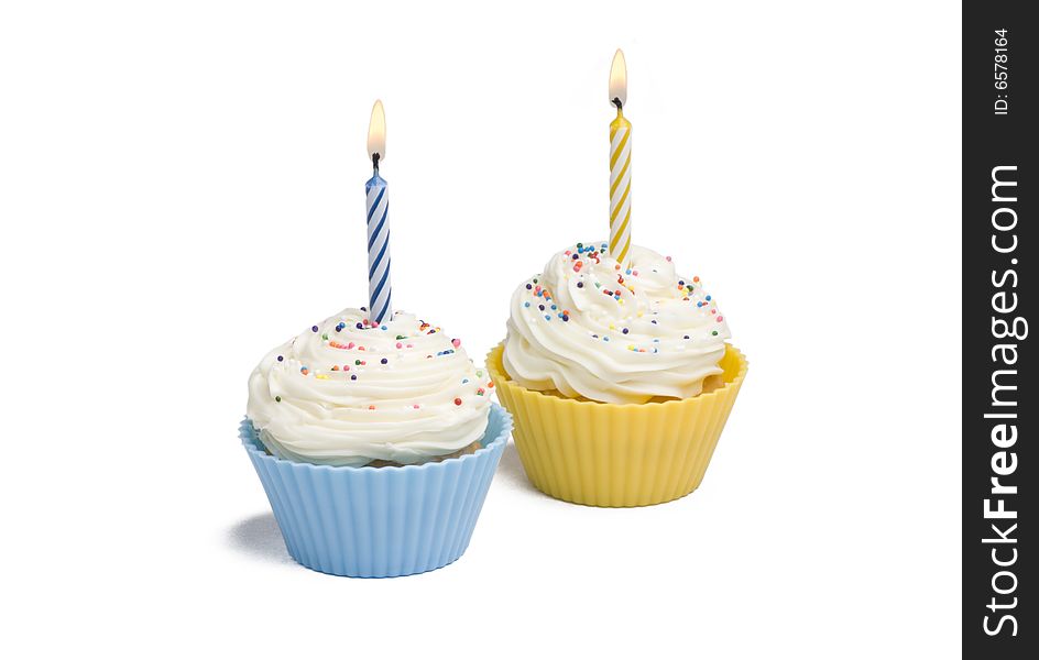 Two cupcakes with candle on white background