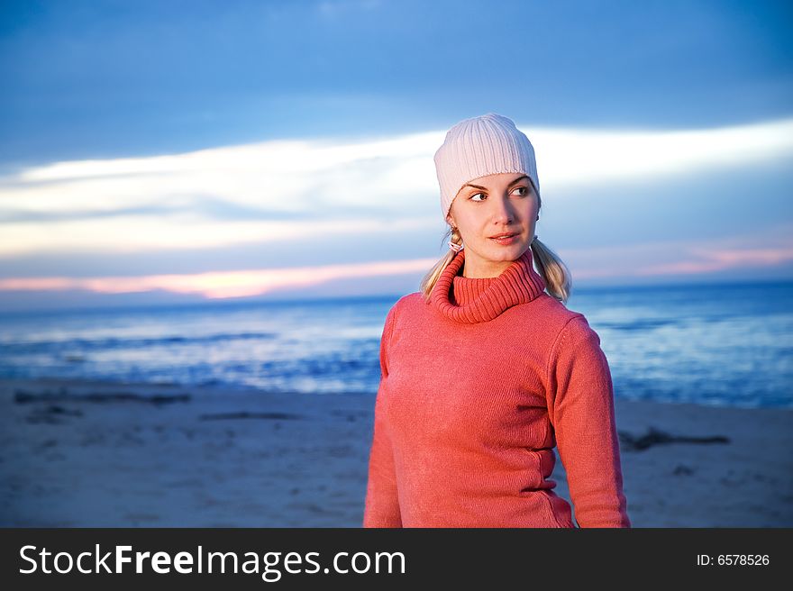 Beautiful young woman relaxing on a beach at evening
