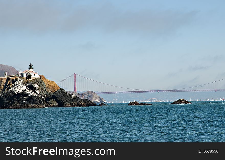 Old lighthouse with Golden Gate bridge in background