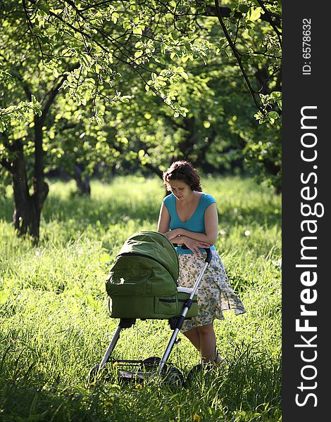 Mother with baby carriage in the park