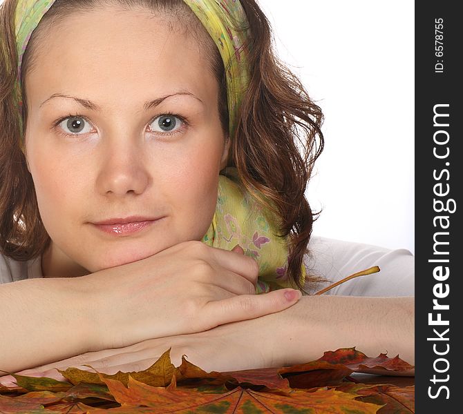 Portrait of Beautiful model with green scarf relaxing on maple leaves