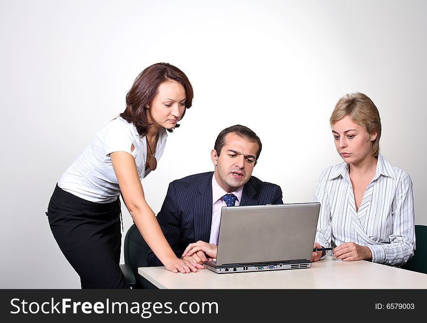 Three colleagues working at a computer.