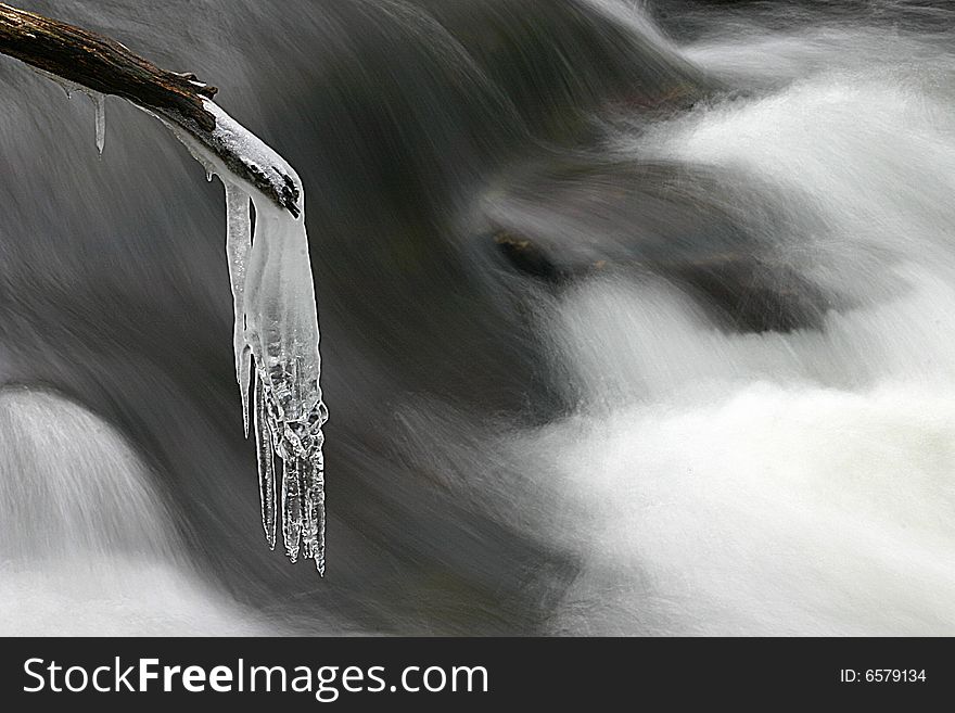 Icicle on branch over mountain stream