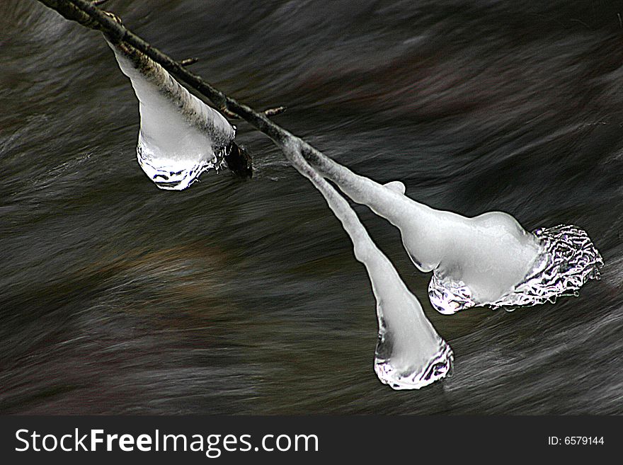 Icicle on branch over mountain stream