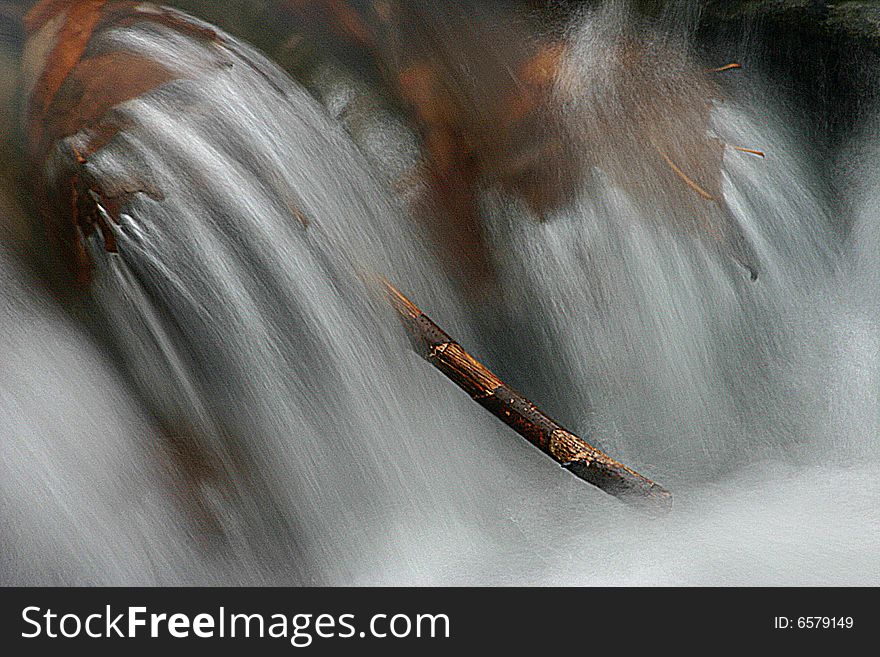 Single, isolated branch in fast flowing mountain stream in winter. Single, isolated branch in fast flowing mountain stream in winter