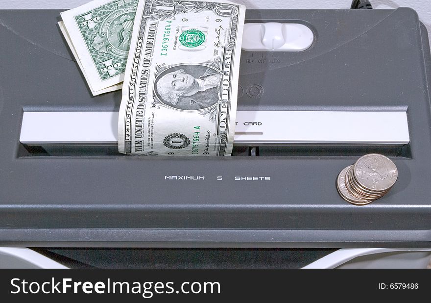 Paper shredder with dollar bills and coins ready to shred. Paper shredder with dollar bills and coins ready to shred