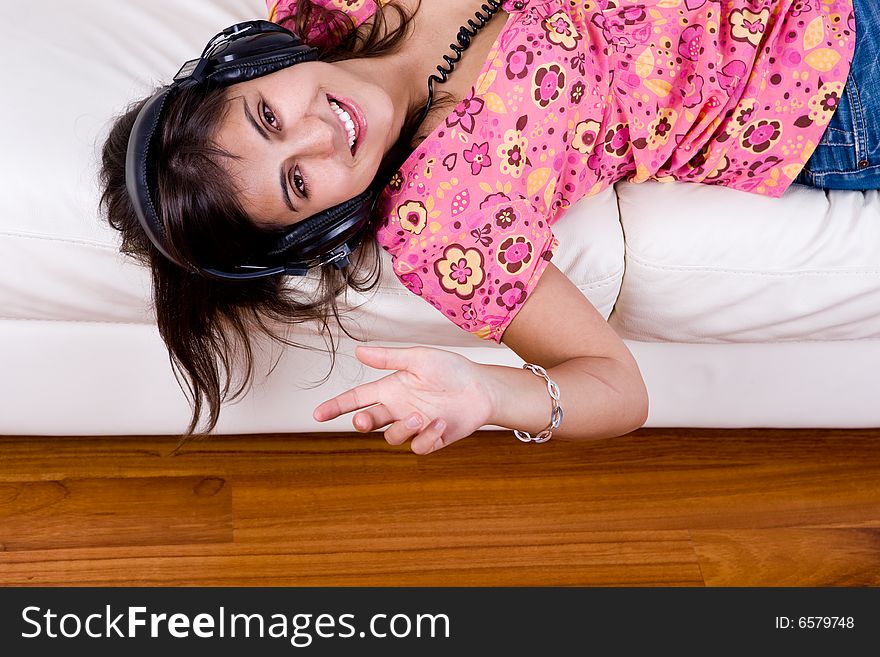 Beautiful young woman listening music with headphones isolated on white