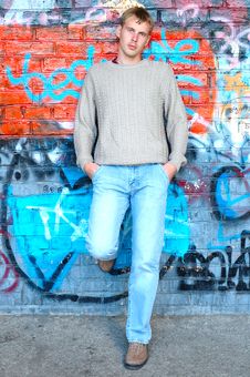 Young Stylish Man Stand Near Graffiti Brick Wall. Stock Image Young Stylish Man Stand Near Graffiti Brick Wall. Stock Image
