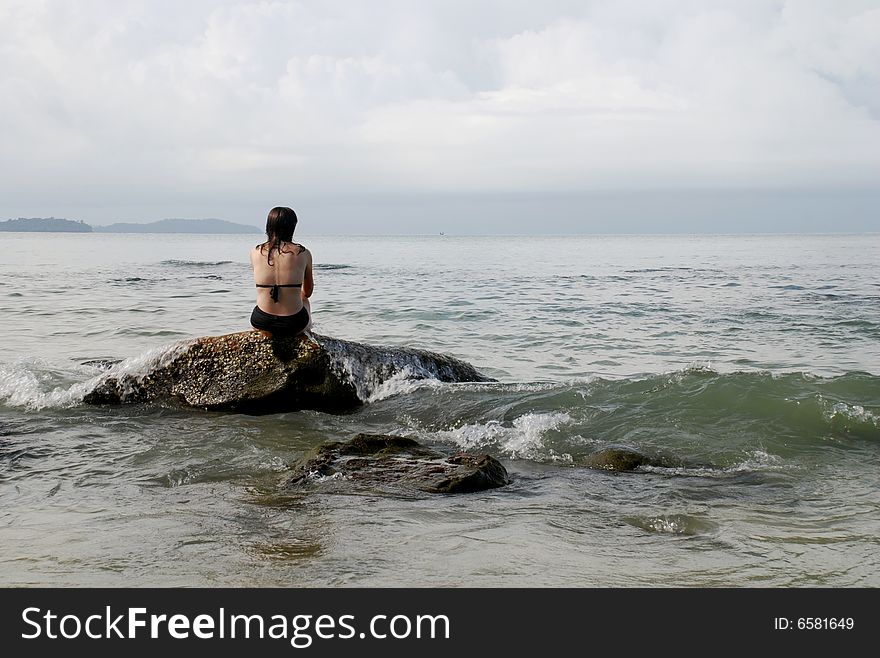 Woman on Wave Covered Rock