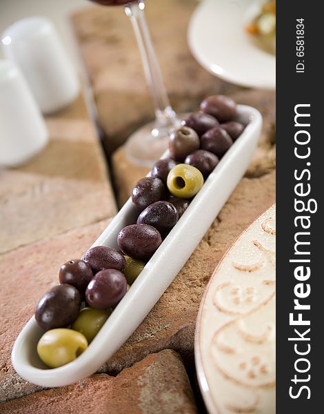 Olives on brick table with glass, shallow depth of field. Olives on brick table with glass, shallow depth of field