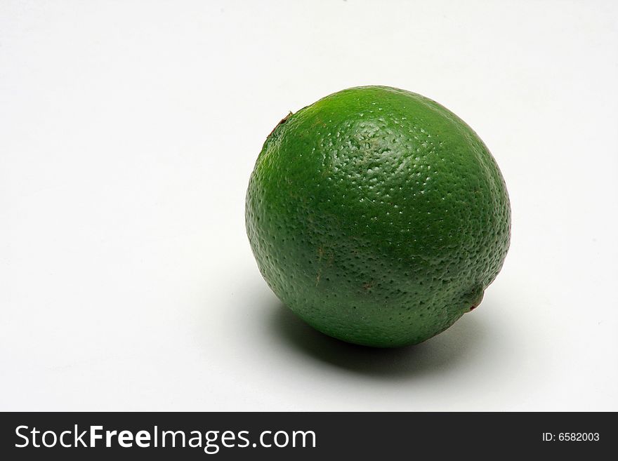 Close up of green lime on white background