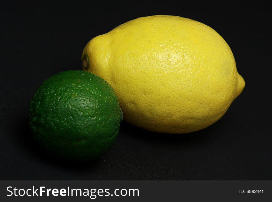 Whole lime and whole lemon on black background. Whole lime and whole lemon on black background