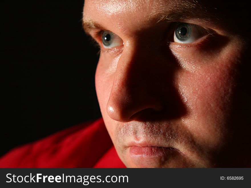 Thinking man in a red shirt in dark