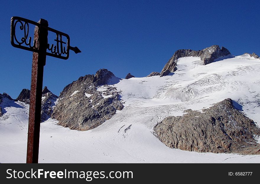 Signpost indicating the way to the mountain hut over the Oberalp glacier in Switzerland, Swiss Alps. Signpost indicating the way to the mountain hut over the Oberalp glacier in Switzerland, Swiss Alps