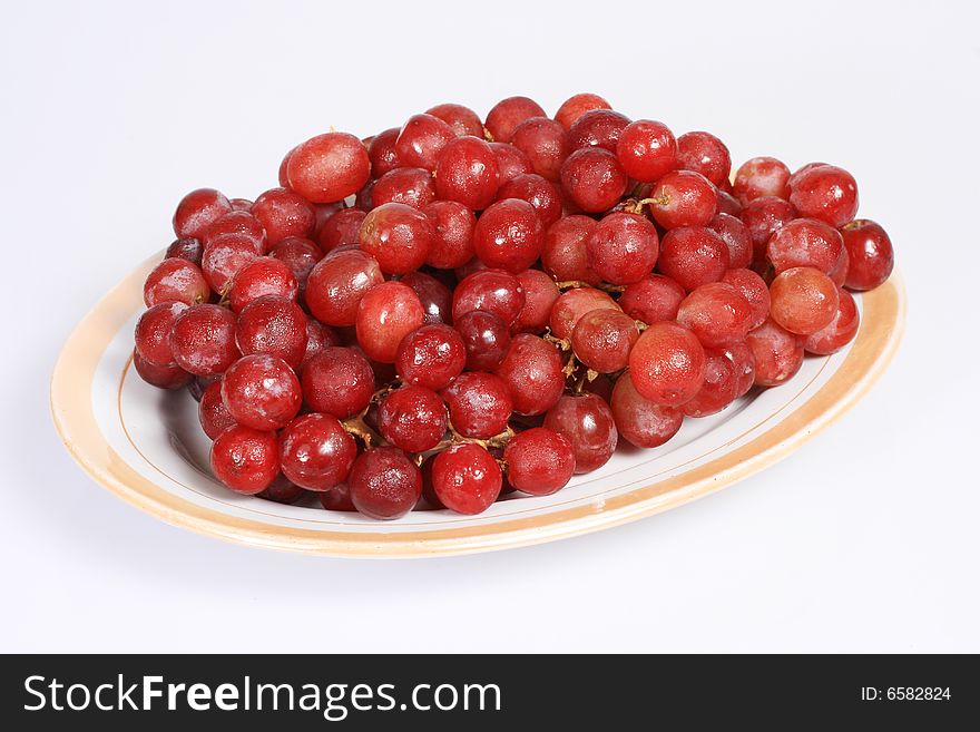 A plate of grapes isolated on white background. A plate of grapes isolated on white background